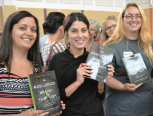 UT-UCS faculty smile for the camera as they wait in line to have their books signed.