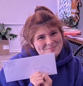 Elizabeth holding an envelope with her voters registration in it