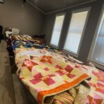 A display of the large number and variety of quilts donated to the boys at Pathways from the Giver Connection.