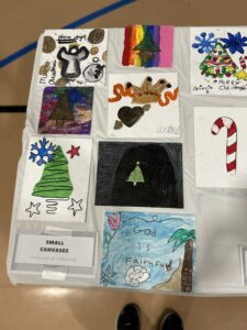 A table featuring 9 different student art projects in a Christmas theme.