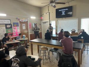 Pathfinders students in a classroom listen to a presentation by Texas Game Wardens on career day.