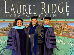 Doctors De La Cruz, Sacriste and Leal in graduate regalia